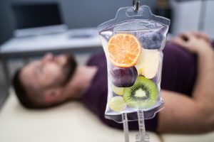 Man In In Hospital Getting IV Infusion Of Fruit Slices Inside Saline Bag
